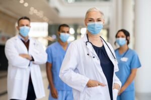 Satisfied doctor with medical staff looking at camera